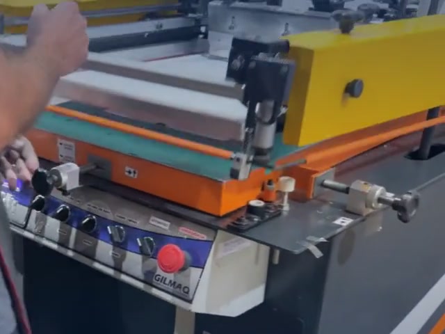 Mesa automática de serigrafia imprimindo decalques na fábrica.